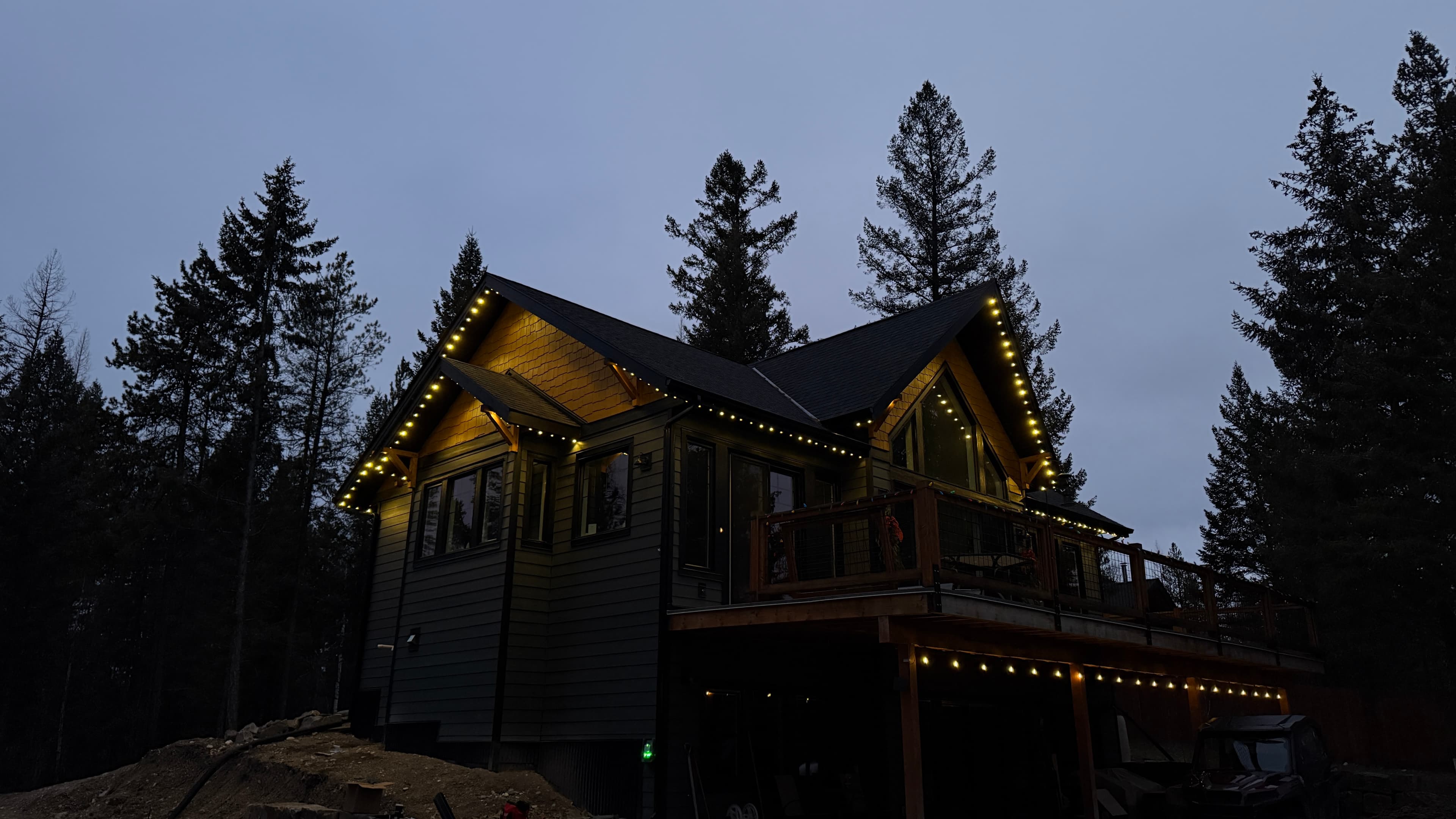 Mountain home roofline with warm, even spacing across gables at dusk.