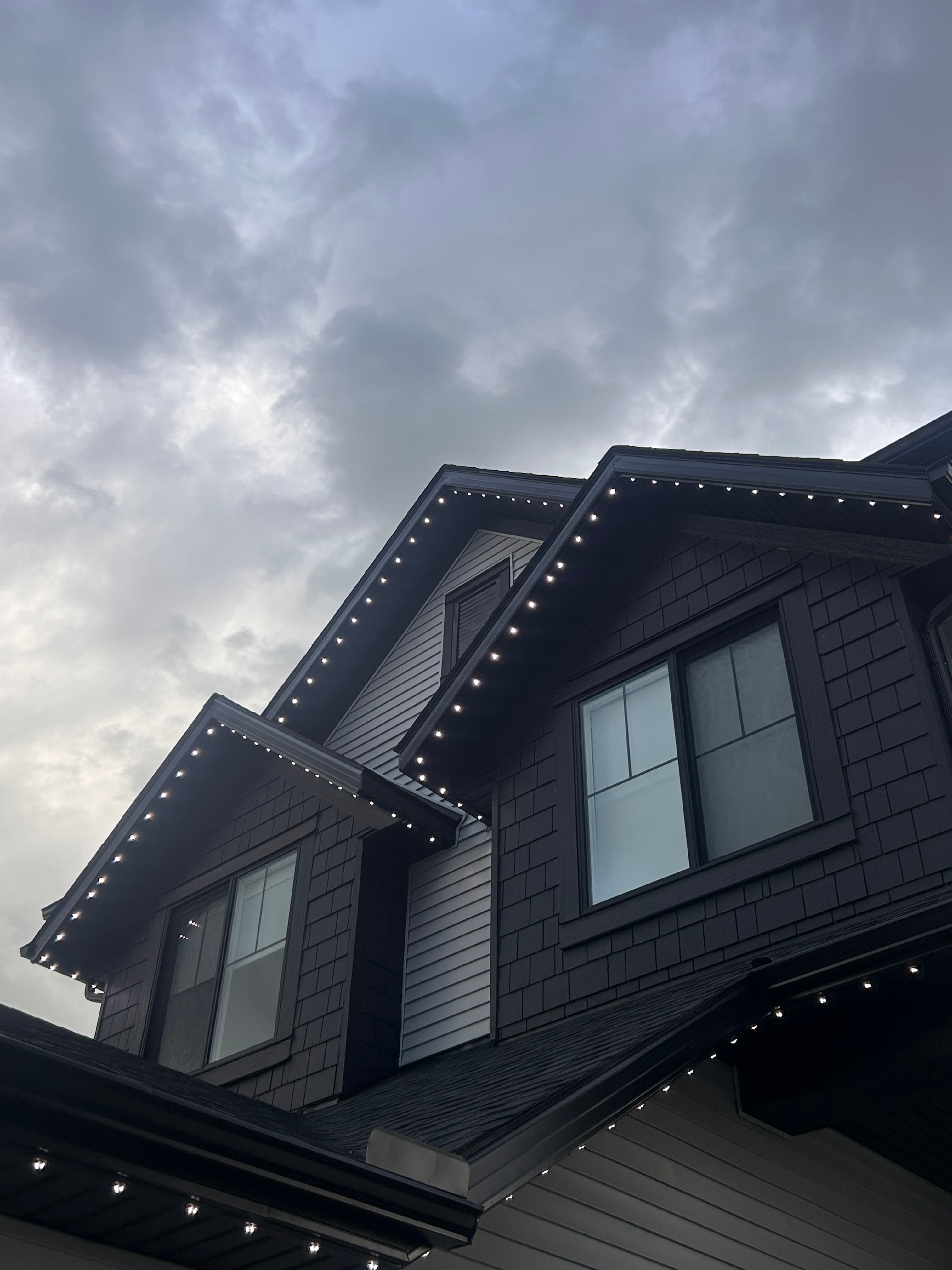 Permanent roofline lighting installed across modern eaves at dusk
