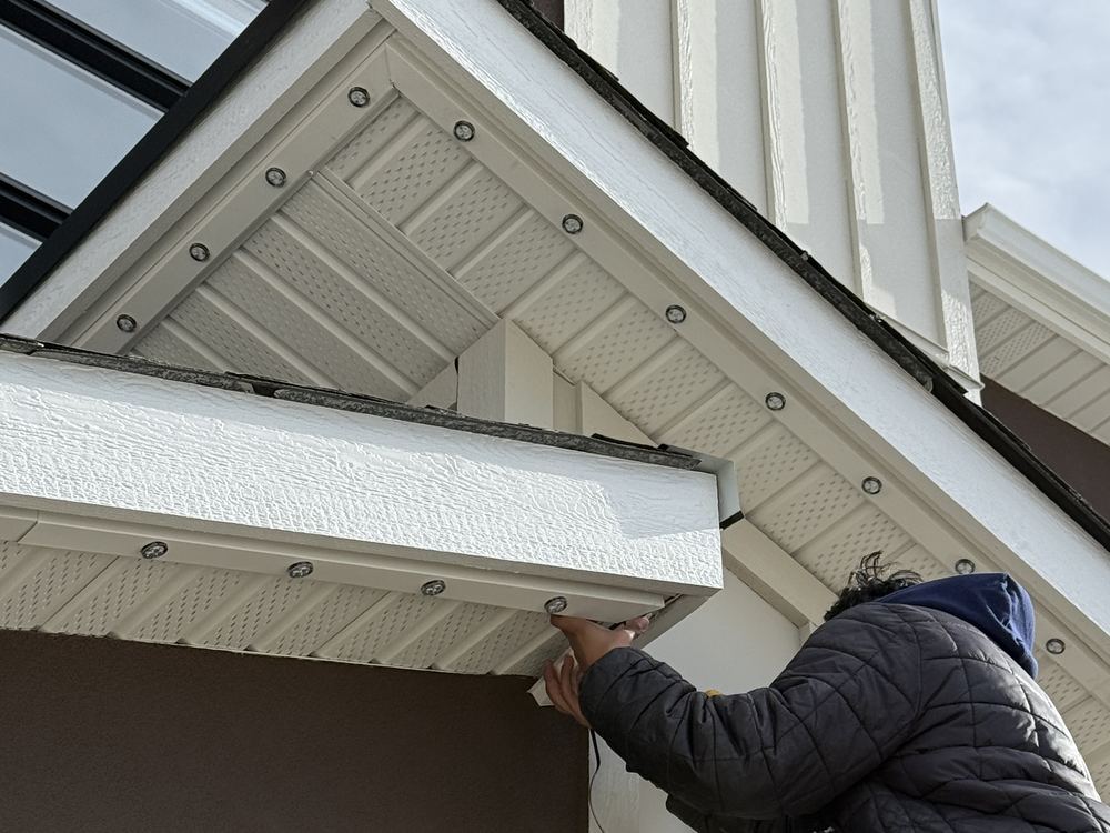 Luminair colour-matched white track being installed along a white soffit and fascia