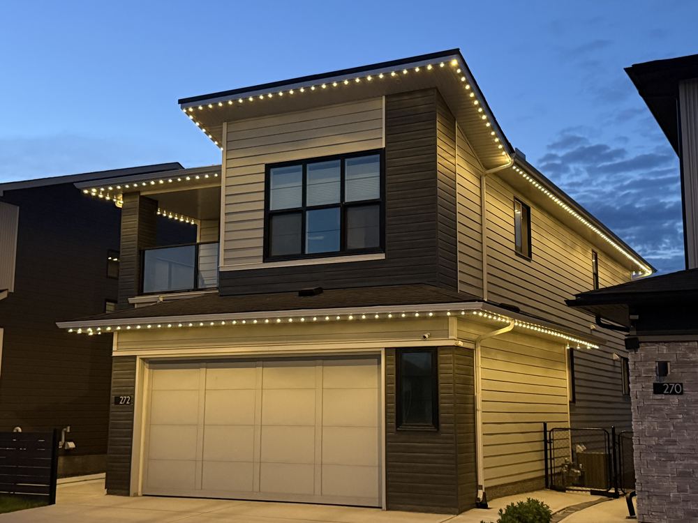 The same track after dark, running warm white along the roofline and eaves of a modern two-storey home
