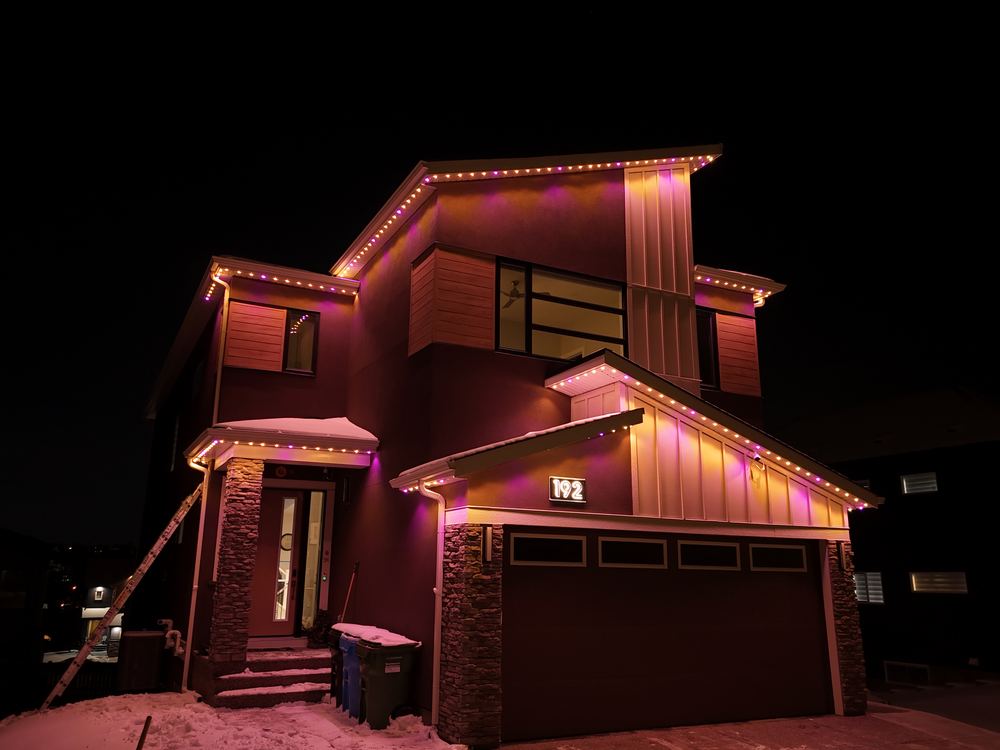 The same modern home running a pink and amber Luminair scene, washing the stucco in warm colour