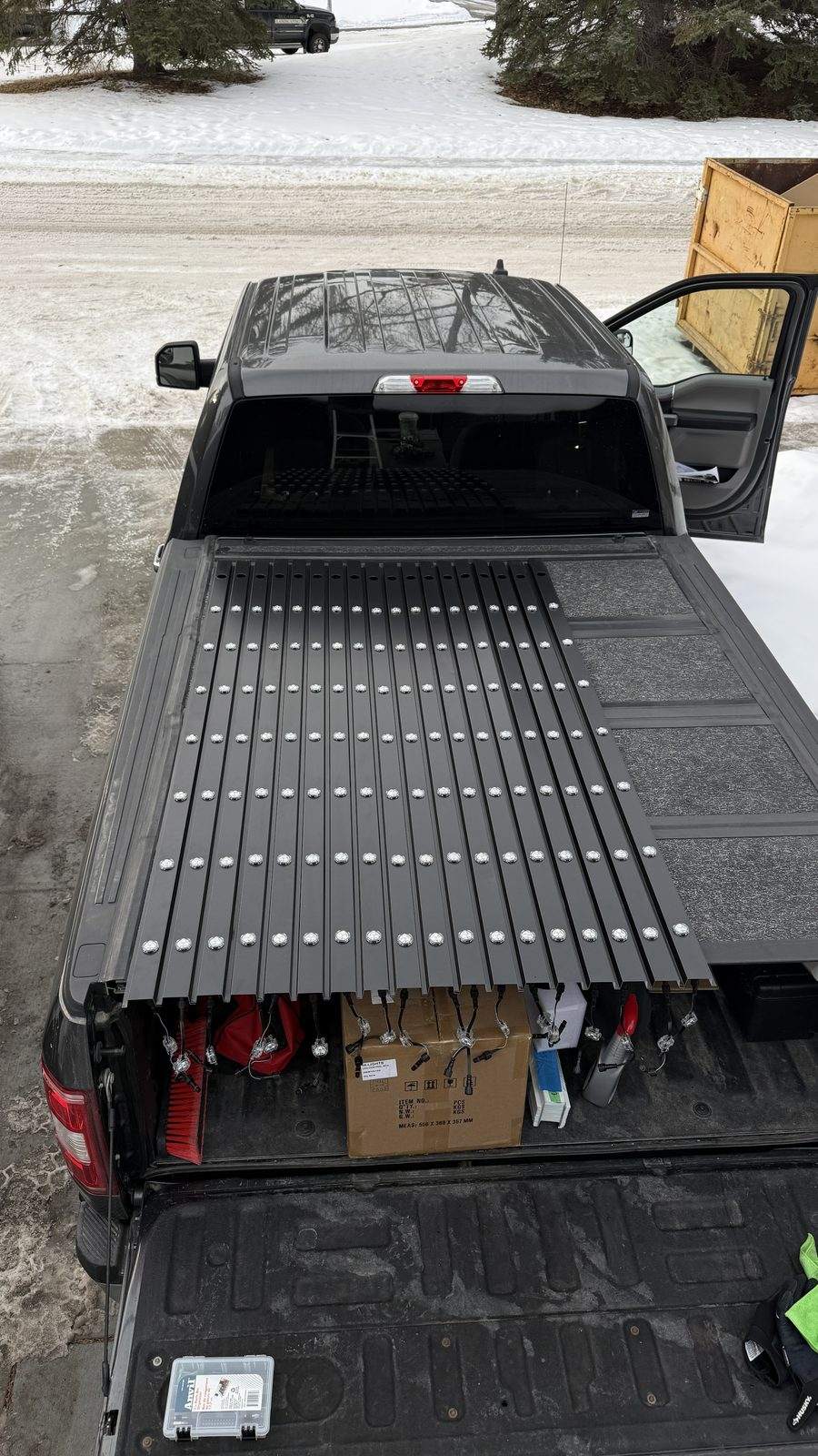 Pre-cut lengths of Luminair aluminum track and sealed LED modules laid out in a truck bed before an installation
